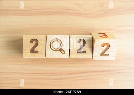 2022 change to 2023 block with magnifying glass icon. SEO, Search Engine Optimization, hiring , Advertising, Idea, Strategy, marketing, Keyword, Conte Stock Photo