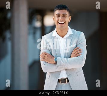 Happy, smile and portrait of young businessman standing outside his modern office building. Happiness, professional and corporate employee from Brazil Stock Photo