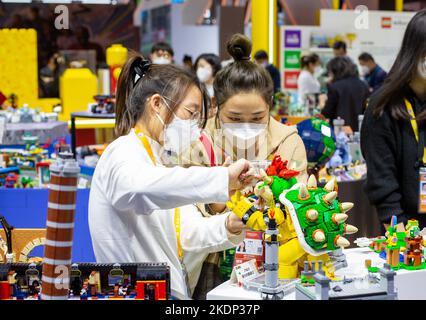 SHANGHAI, CHINA - NOVEMBER 7, 2022 - Visitors experience Lego toys at the booth of the Consumer Goods section of the Fifth International Import Expo ( Stock Photo