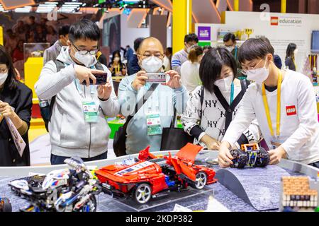 SHANGHAI, CHINA - NOVEMBER 7, 2022 - Visitors experience Lego toys at the booth of the Consumer Goods section of the Fifth International Import Expo ( Stock Photo