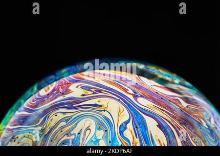 Virtual reality space with abstract multicolor psychedelic planet. Closeup Soap bubble like an alien planet on black background Stock Photo