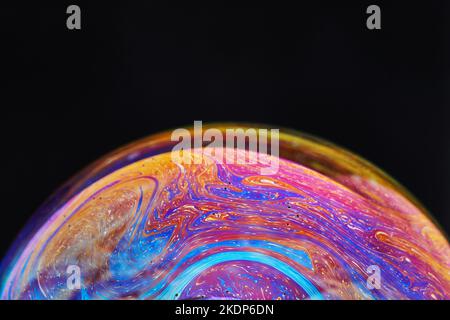 Virtual reality space with abstract multicolor psychedelic planet. Closeup Soap bubble like an alien planet on black background Stock Photo