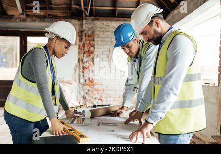 Architect, construction and teamwork with an engineer, designer and technician working together on a blueprint. Meeting, planning and architecture Stock Photo