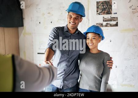 Handshake, construction and couple consulting, planning and doing inspection of home renovation with a contractor. Meeting, thank you and man and Stock Photo