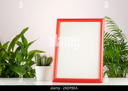 Eco friendly still life. Home plantes and empty picture frame mockup on white desk, table. Elegant working space, home office concept. Scandinavian in Stock Photo