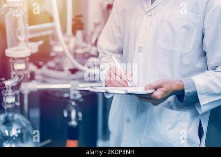 medicine science factory staff worker check quality products sterilize in autoclave tank in check list. Stock Photo