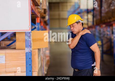 warehouse worker back shoulder muscle pain injuries from heavy lifting hard working. Stock Photo