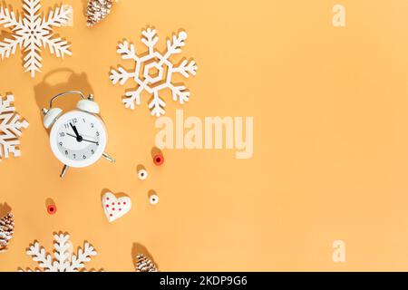 Christmas composition. Wooden decorations, alarm clock and cones on a peach background. Christmas, winter, new year concept. Flat lay, top view, copy Stock Photo