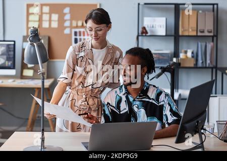 Portrait of smiling man and woman collaborating on creative design project in office setting Stock Photo