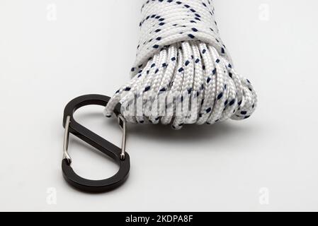 White braided polypropylene rope with black carabiner isolated on white background Stock Photo