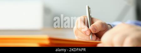 Male hand writing personal address on yellow envelope Stock Photo