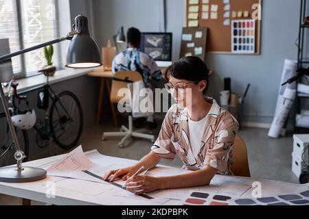 Portrait of smiling young woman working on interior design project in office, copy space Stock Photo