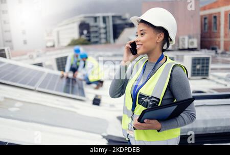 Solar energy, solar panels and electrician on a phone call networking, talking or speaking to a technician. Engineering, roof and happy woman in Stock Photo