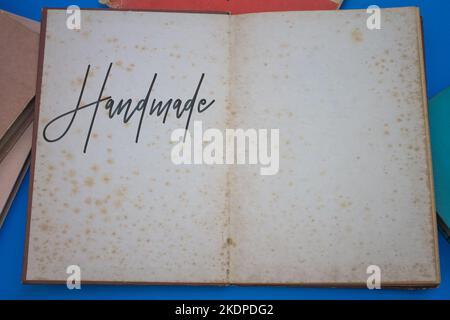 Handmade word in opened book with vintage, natural patterns old antique paper design. Stock Photo