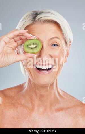 Kiwi, fruit and wellness of a senior woman with beauty skincare, health and a smile. Portrait of an happy elderly model holding food feeling happiness Stock Photo