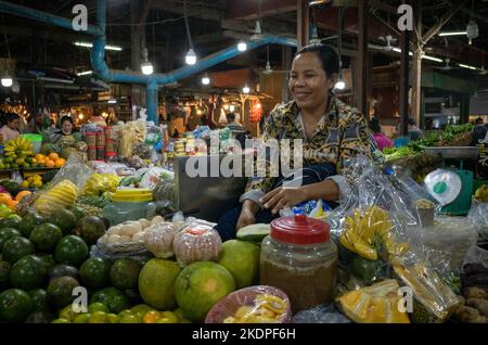 A woman sells fruit at her stall within Siem Reap Old Market in Cambodia. Stock Photo