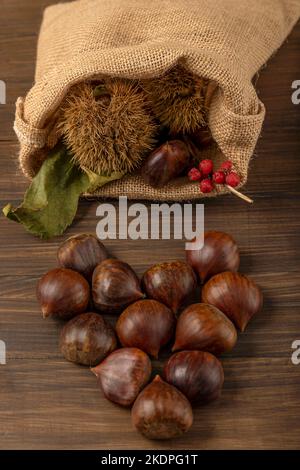 A heart made up of chestnuts coming out of a jute sack Stock Photo