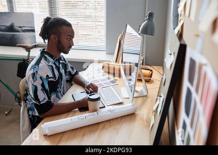 Side view portrait of male designer focused at work in home office Stock Photo