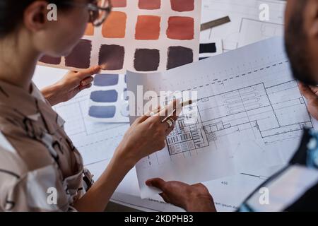 Close up of two architects discussing floor plans and color swatches for interior design project Stock Photo