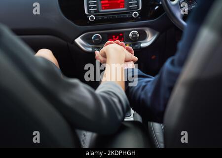 Love is a journey best traveled together. a couple holding hands while going for a drive. Stock Photo