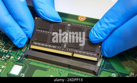 Installing a RAM module on a laptop motherboard close-up Stock Photo