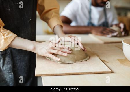 Close up of young woman shaping handmade ceramic bowl in cozy pottery studio, copy space Stock Photo