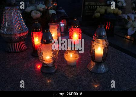 Lighting candles on the grave at night. All the Saints Day holiday on 1 November in Poland Stock Photo