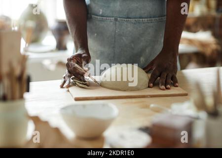 Warm toned closeup of man creating beautiful handmade bowl in pottery studio Stock Photo