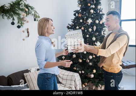 Two happy people exchanging xmas gifts Stock Photo