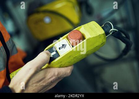 The ominous red button. an unidentifiable engineer holding a control switch in his hand. Stock Photo