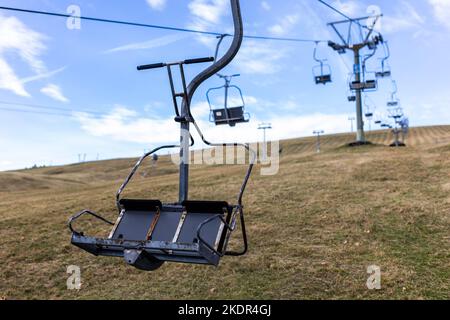 Feldberg, Germany. 08th Nov, 2022. The seat of a chairlift hangs on a wire rope near the valley station of the Feldbergbahn. The first snow that fell over the weekend has already melted again due to double-digit temperatures. The Feldberg lift association is presenting its plans for the 2022/23 winter season during a press conference today. Credit: Philipp von Ditfurth/dpa/Alamy Live News Stock Photo