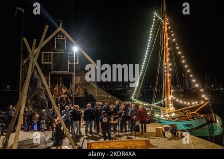 Enkhuizen, Netherlands. October 2022. An old flatboat and a shanty choir in Enkhuizen harbor. Evening shot. High quality photo Stock Photo