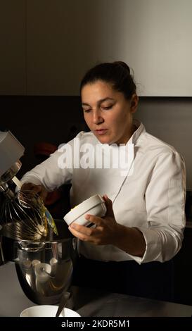 vertical shot of Young woman pastry chef making cookies in her bakery Stock Photo