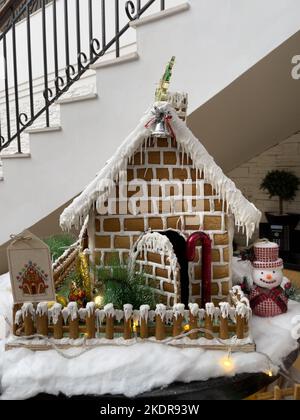 beautiful gingerbread house placed on a table Christmas themed decorations all around it. Stock Photo