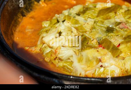 Cabbage is cooked in cauldron on fire. Step by step cooking of Chorba. Stock Photo