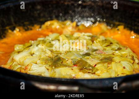 Cabbage is cooked in cauldron on fire. Step by step cooking of Chorba. Stock Photo