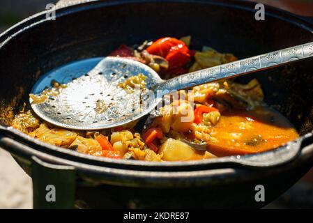 Vegetable Chorba in cauldron on fire. Stock Photo