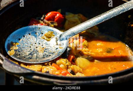 Vegetable Chorba in cauldron on fire. Stock Photo