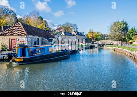 The Bradford and Avon canal at Bradford on Avon in West Wiltshire with a narrowboat moored up near the bridge and lock gates Stock Photo