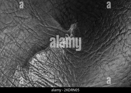 Torn ripped fabric black dark color material old textile canvas vintage leather. Stock Photo