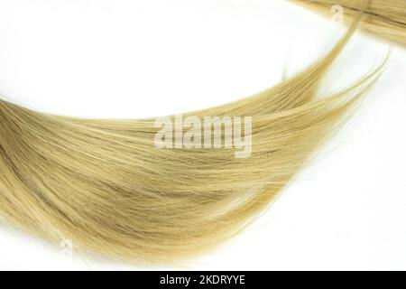 Blond shiny hair wave, on white. Strand of blond hair on white. Curls of hair Stock Photo