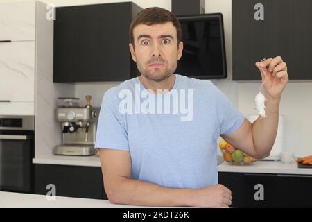 Man catching a mouse in his kitchen Stock Photo