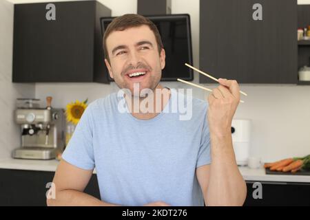 Man ready to eat with pair of chopsticks Stock Photo