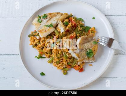 Fish with brown rice and vegetables on a plate isolated on white background Stock Photo