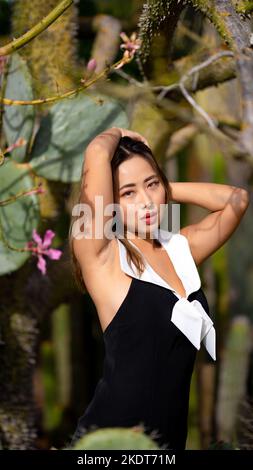 Close Up of Young Woman in a Garden Surrounded by Cactus Plants Stock Photo