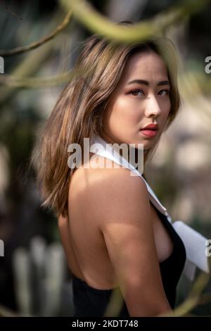 Close Up of Young Woman in a Garden Surrounded by Cactus Plants Stock Photo