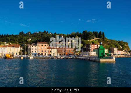 Piran, Slovenia - September 17th 2022. A small green lighthouse on the waterfront of the historic medieval town of Piran on the coast of Slovenia Stock Photo
