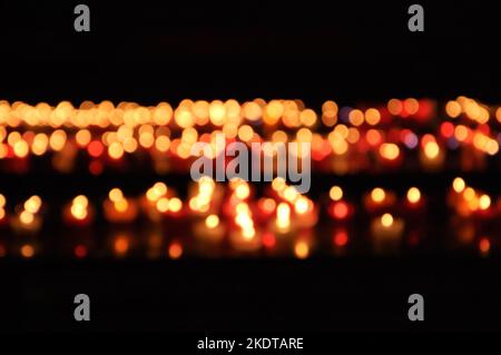 Blurry burning candles in dark church background. Bokeh. Celebration, memorial concepts Stock Photo