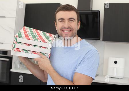 Man holding two pizza boxes at home Stock Photo