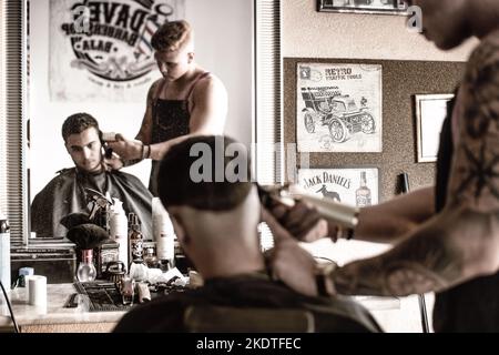 Barber cutting hair in a barber shop in Hungary Stock Photo